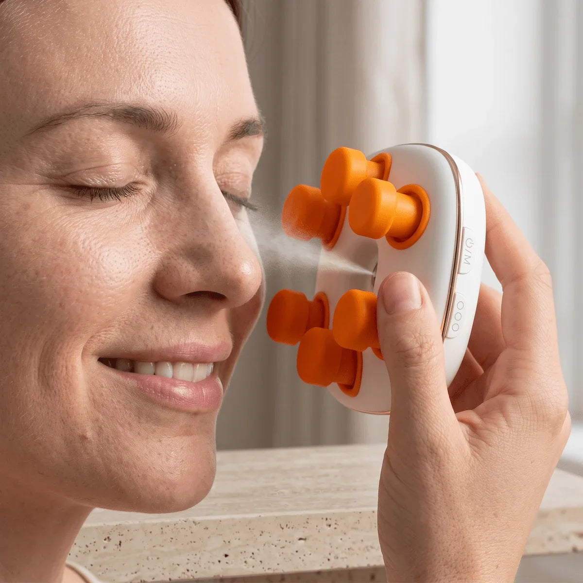 A woman with authentic skin texture using the Elevaure handheld eye massager at home.