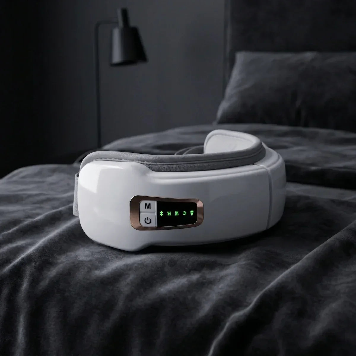 Heated eye massager placed on soft bedding, illustrating a relaxing nighttime routine to relieve digital eye strain and dry eyes.