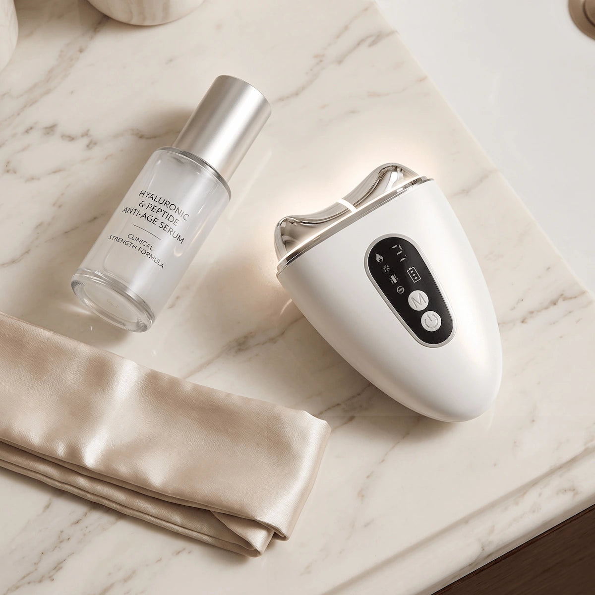 A flat lay of a nightly skincare routine featuring peptide serum and the Elevaure EMS device for at-home jawline contouring.