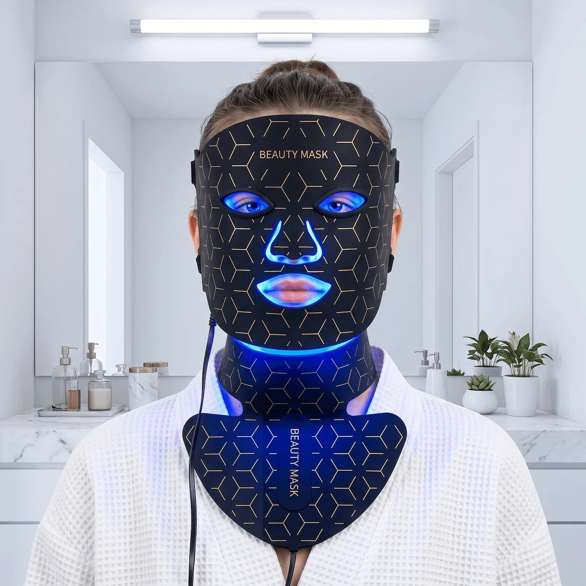 Young woman using the blue light setting on a silicone LED mask to treat active breakouts and acne.