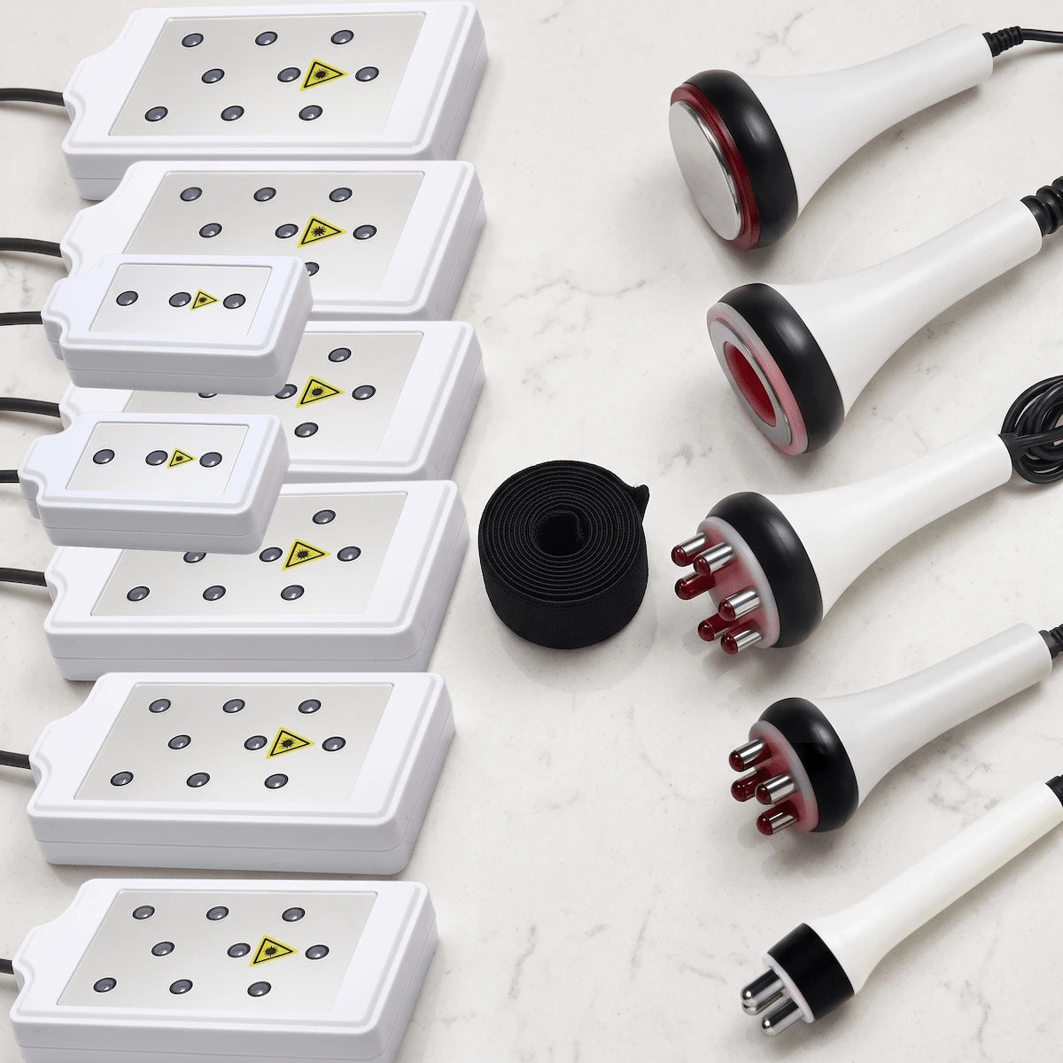 Flat lay presentation of all 6-in-1 system attachments, including 8 LLLT pads, RF probes, cavitation head, and vacuum handle.