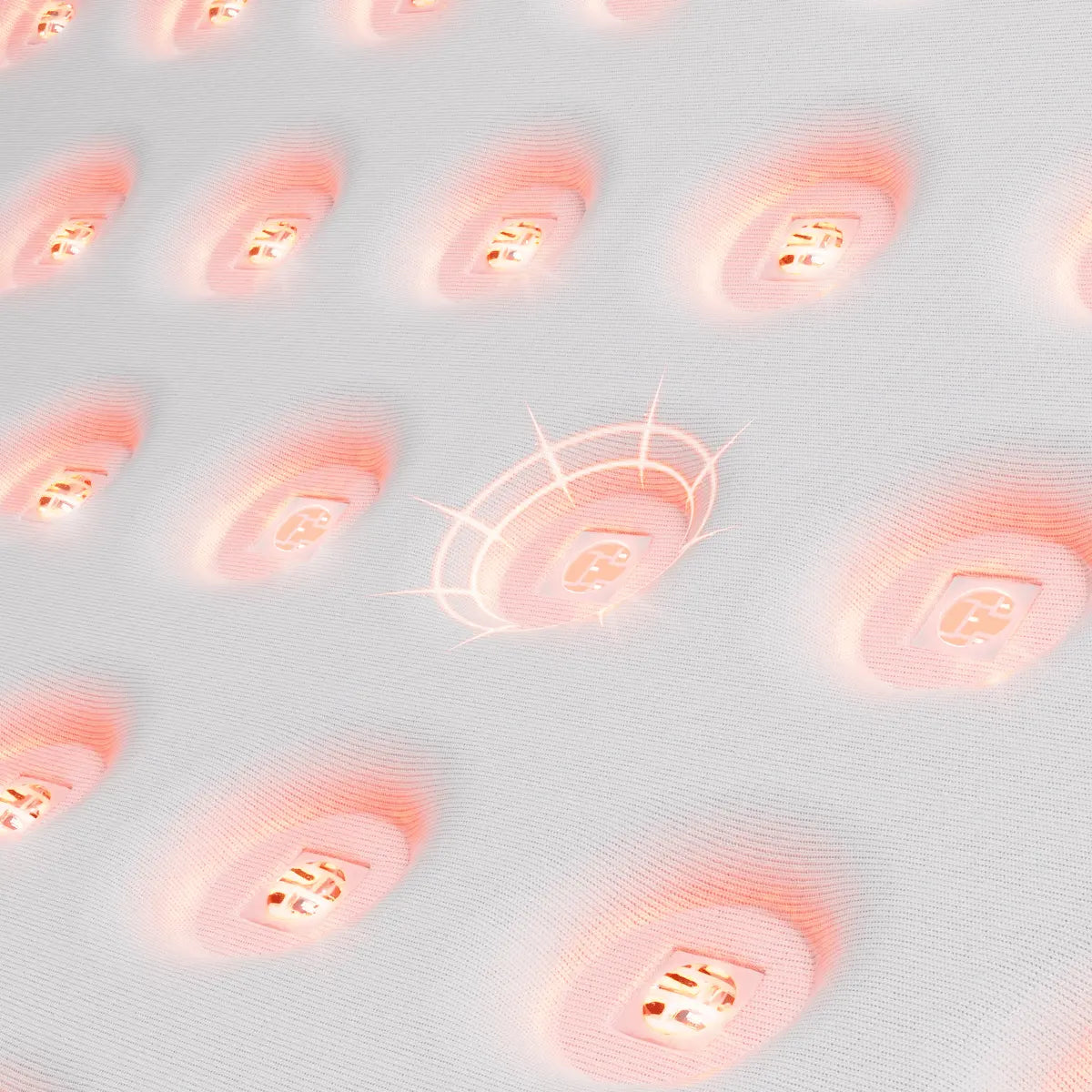 Macro close-up of the convex mirror drop-glue lens on the red light therapy pad, concentrating light energy and reducing optical loss across the treatment surface.