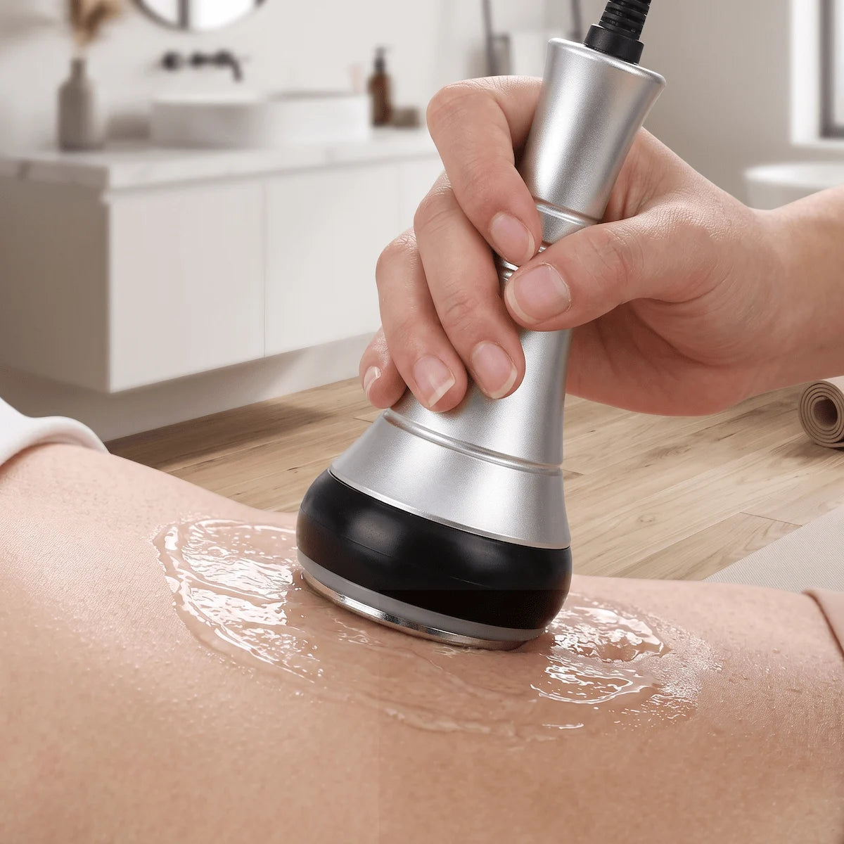 Woman lying on sofa using RF body sculpting device on abdomen at home in natural light