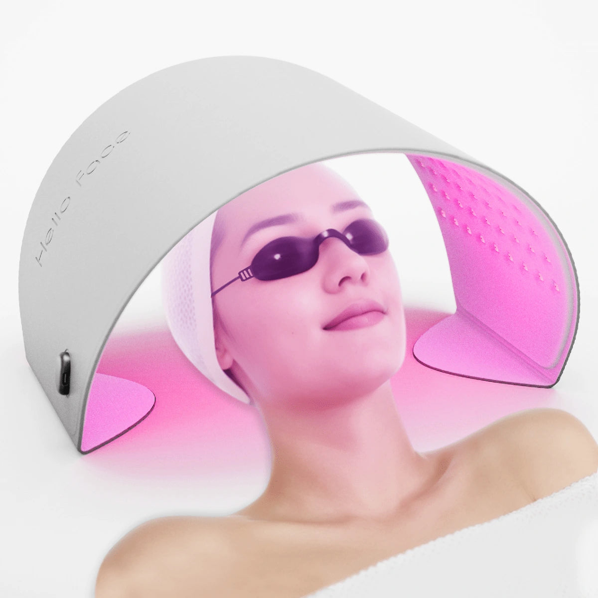 Detailed portrait of a woman with radiant smooth skin resting under the pink light of the Elevaure flexible LED therapy wrap with eye protection.