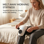 Person using the ELEVAURE heated knee massager at home in the morning with adjustable heat settings.