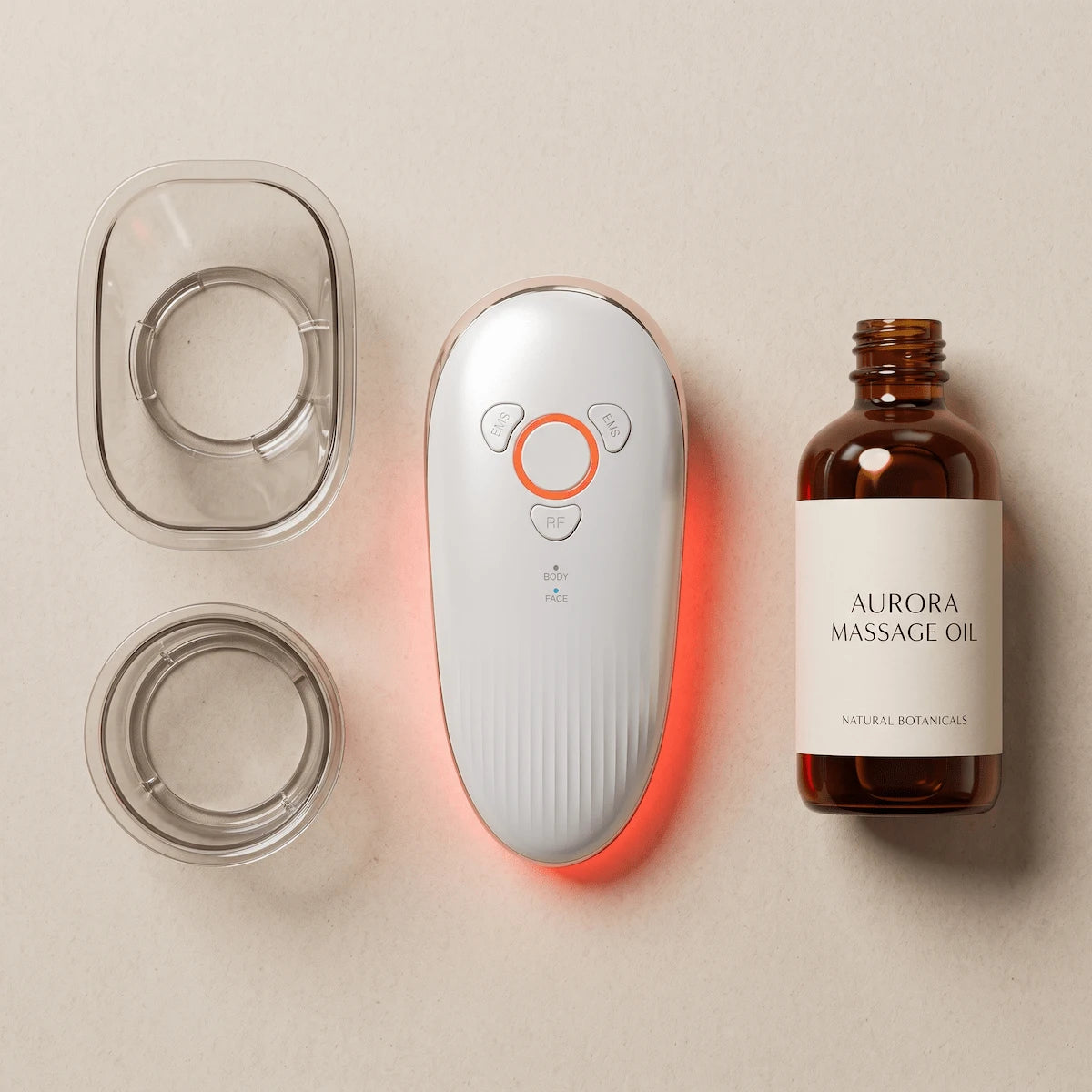 Flat lay of the Elevaure Face & Body Sculpting Massager with two interchangeable LIPO suction cups and a bottle of massage oil, showing the recommended setup for a body sculpting session at home.