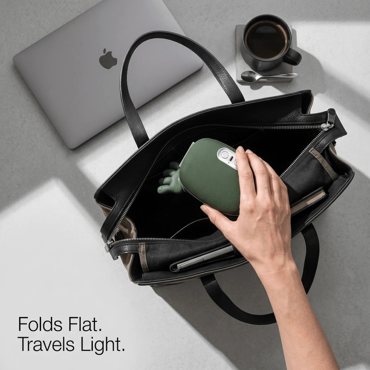 Folded lightweight wearable neck massager elegantly placed inside a premium commuter tote bag, demonstrating its portable desk-friendly design.