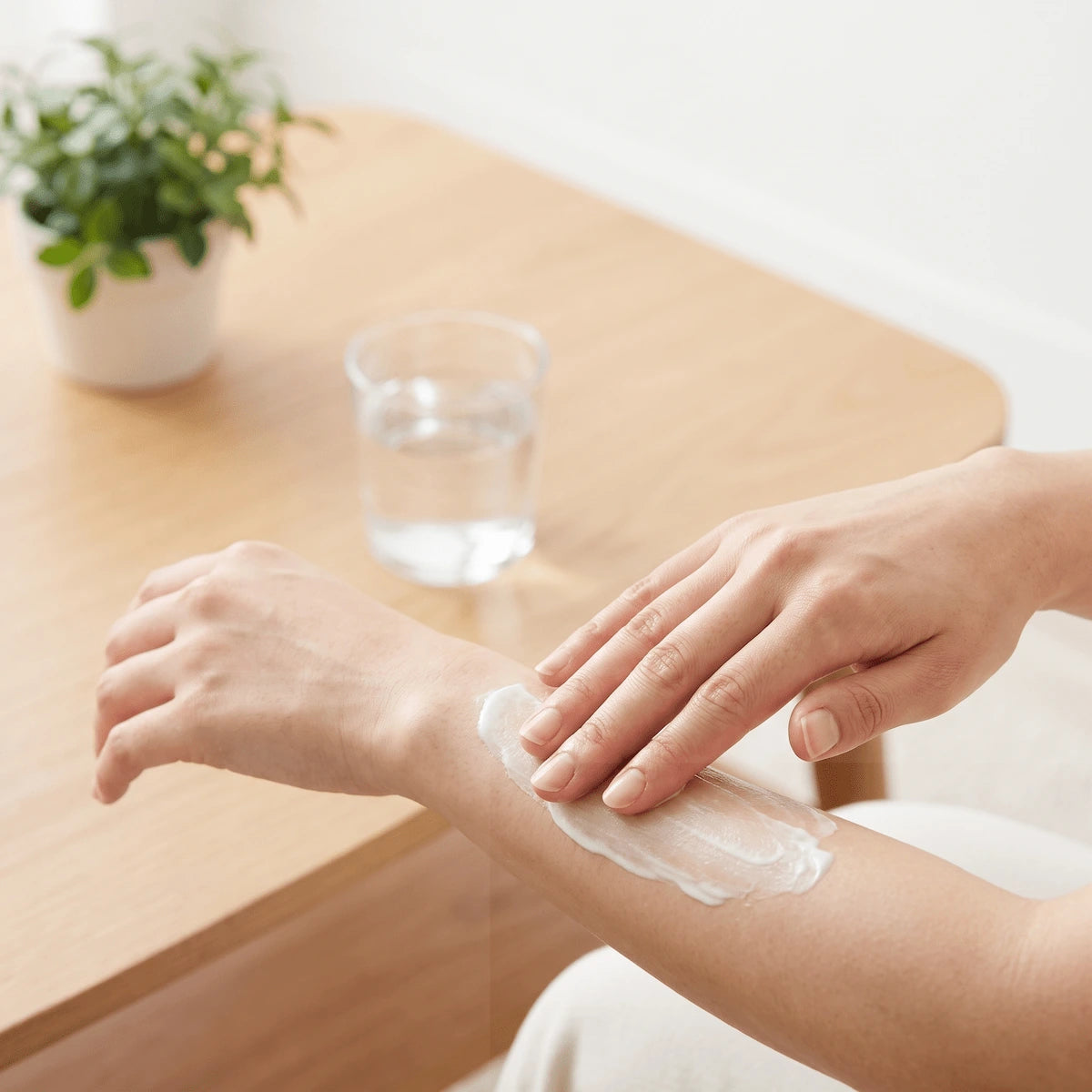 Applying a firming body serum and drinking water to support recovery after a home spa session.