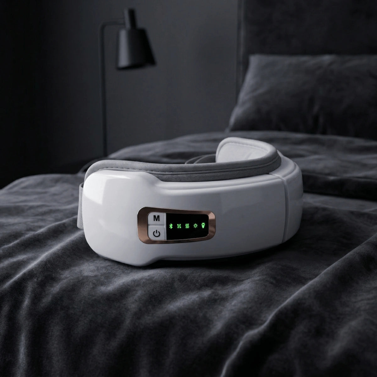 The heated eye massager placed on soft bedding, ready for nightly sleep preparation.