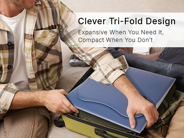 Travel suitcase opened flat on a bed showing the compact tri-fold red light therapy pad packed neatly with its power adapter and controller.