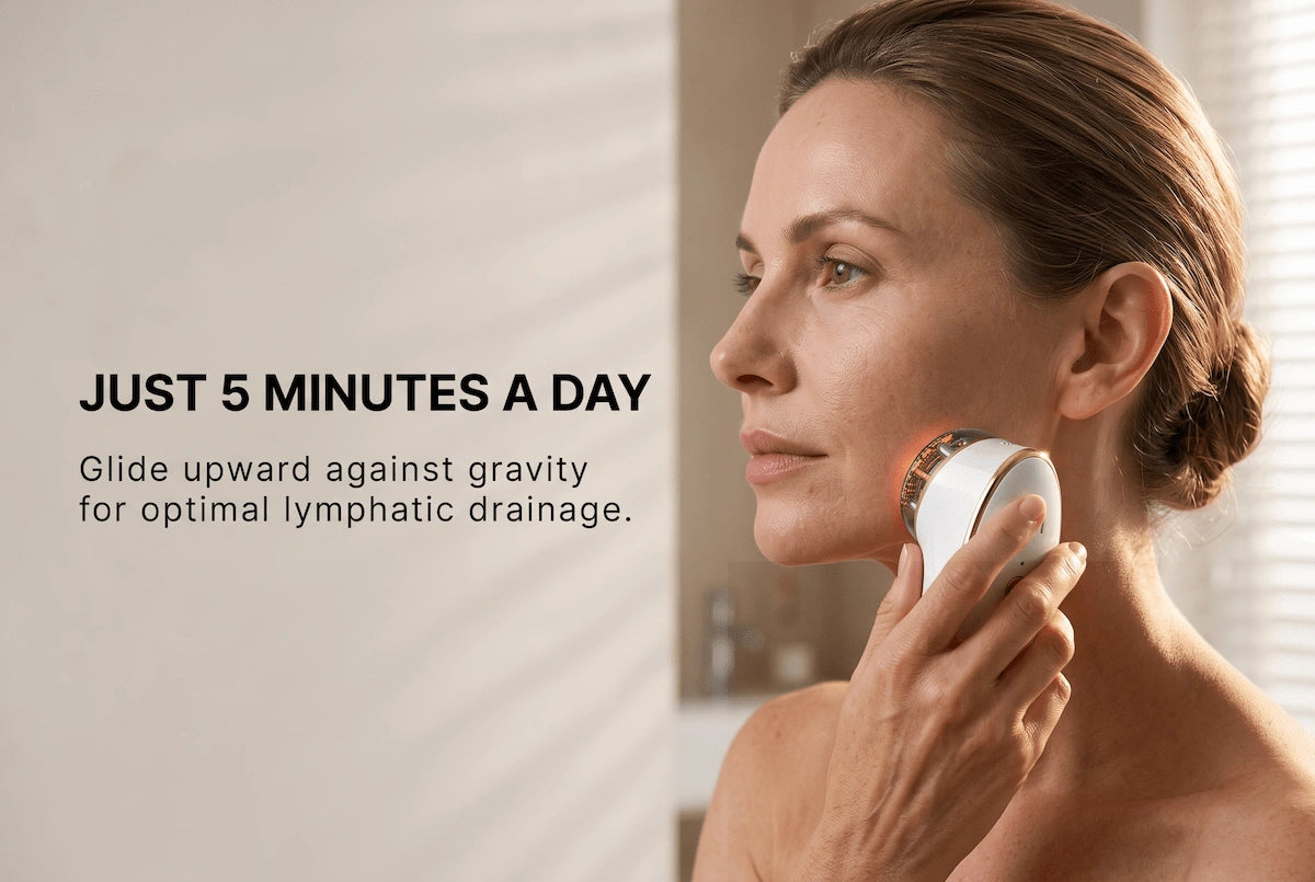 A woman correctly holding and using the ELEVAURE EMS device along her jawline for lifting and contouring in a natural home setting.