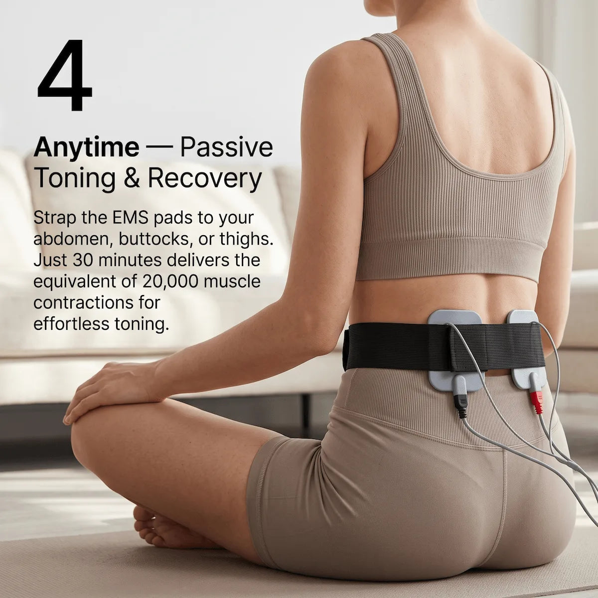 Woman wearing EMS electrode pads strapped to her lower back for passive muscle toning and recovery.