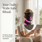 A woman relaxing at home while wearing the flexible Elevaure LED phototherapy mask and chest attachment, showcasing real skin texture.